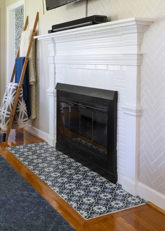 A rental fireplace painted white with Floor Pops! titles installed on the hearth