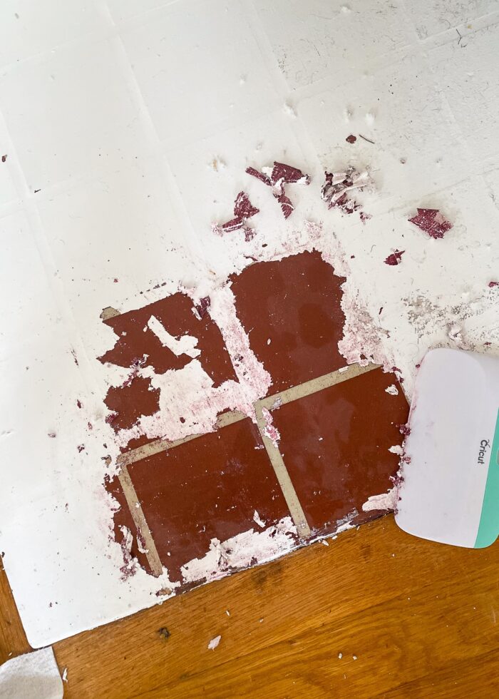 Paint peeling off maroon tile
