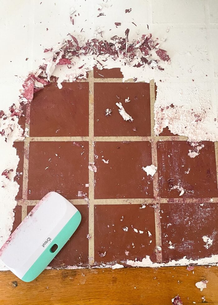 Paint being removed from maroon tile