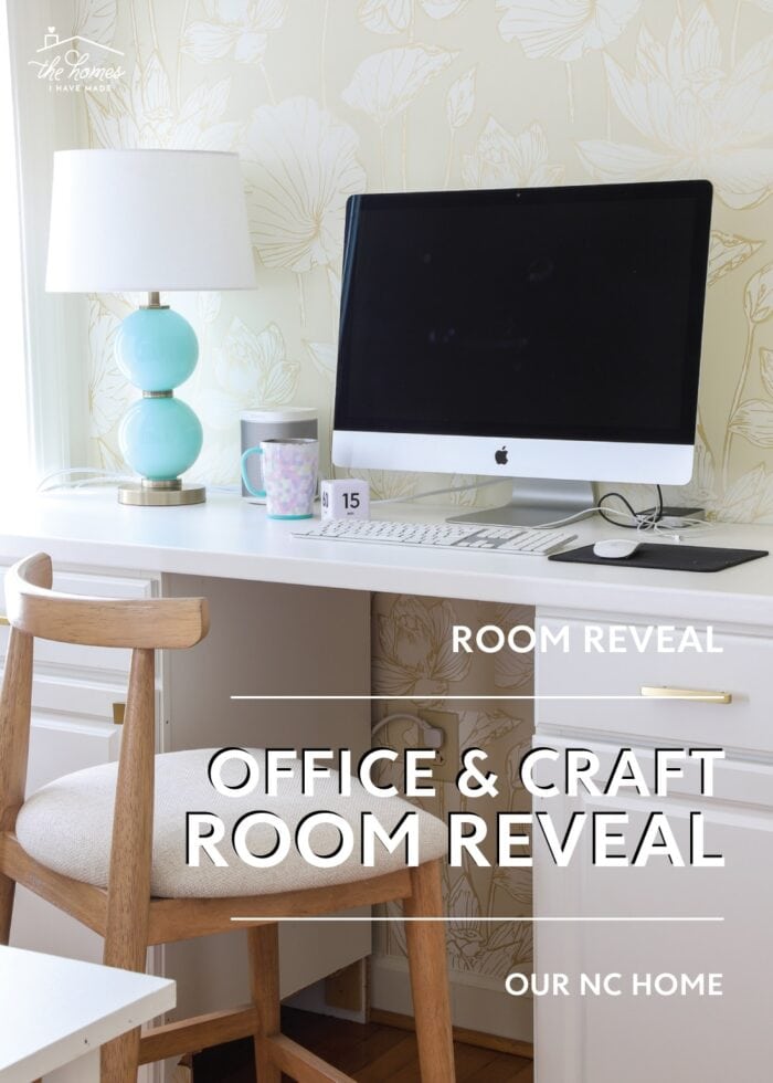 Computer station setup on a white countertop with a wood stool and turquoise lamp