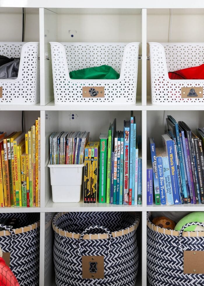 Books on an IKEA Kallax shelf organized by color
