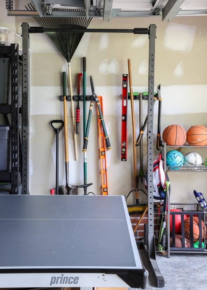 Lawn and garden tools mounted to the wall in a garage