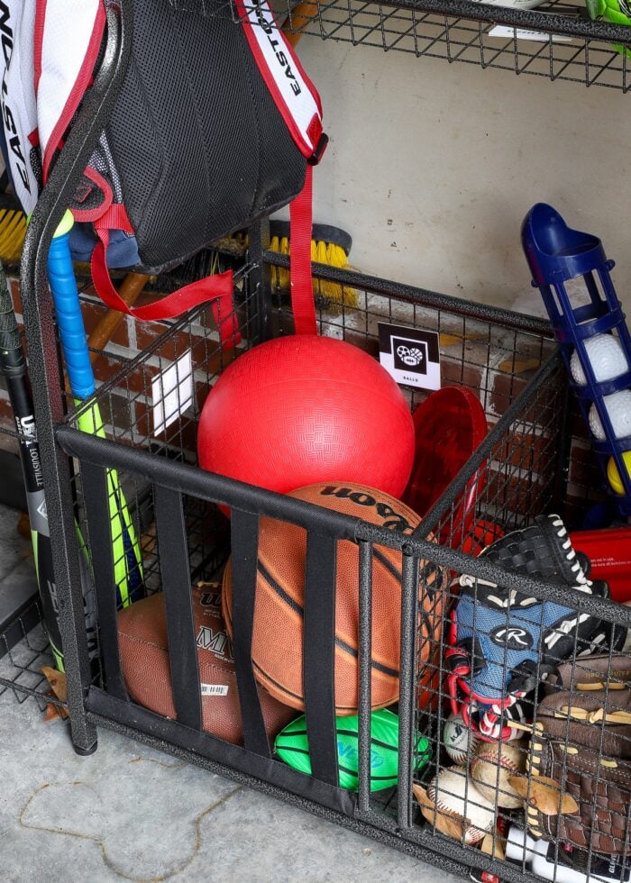 A variety of balls in a garage sports equipment rack