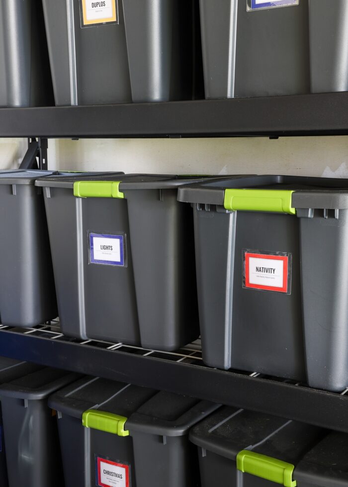 Labeled storage bins on a shelf in an organized garage