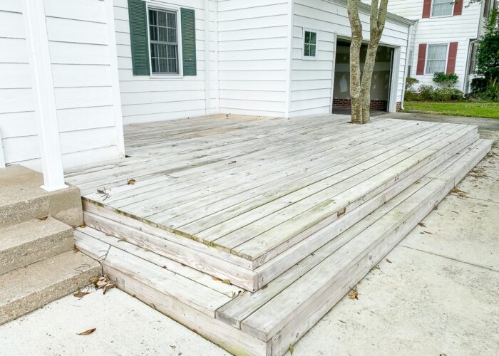 Unfinished wood deck on the front of a house