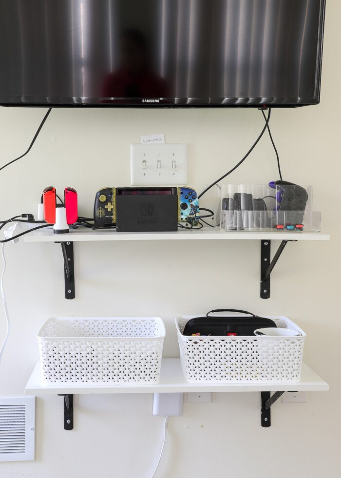 Wall-mounted shelves with gaming accessories inside baskets