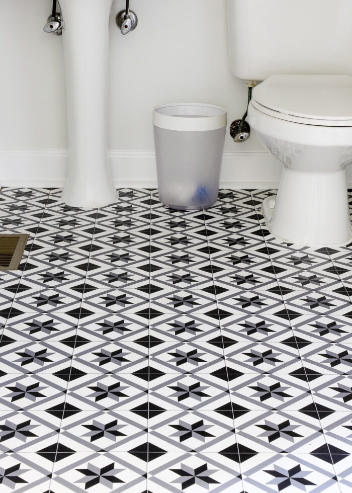 Black and white vinyl mat on the floor of a powder room