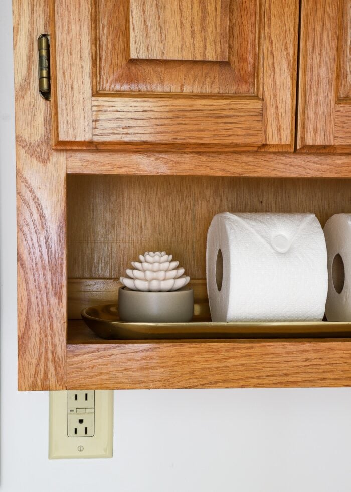 Diffuser and toilet paper on a bathroom shelf