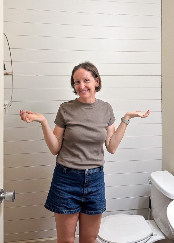 Megan standing in front of a shiplap wall