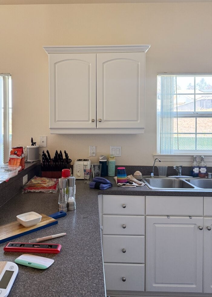 Rental kitchen with small white cabinets and yellow walls