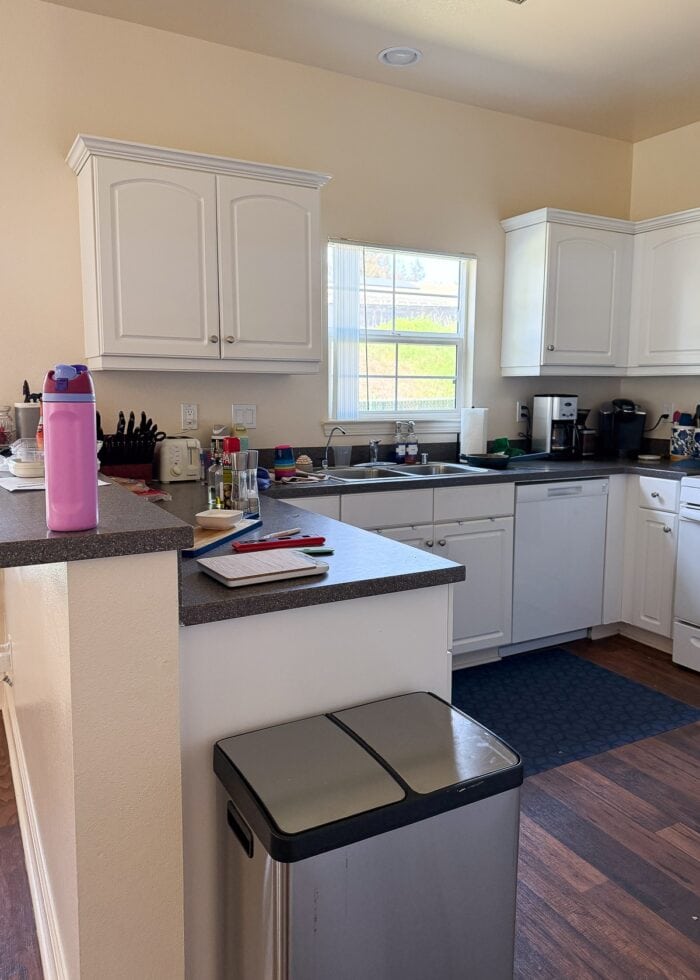 Rental kitchen with small white cabinets and yellow walls