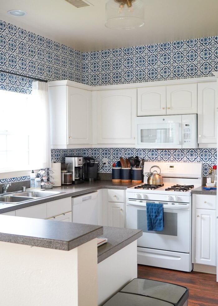 Small white kitchen with blue and white "tile" backsplash done with wallpaper