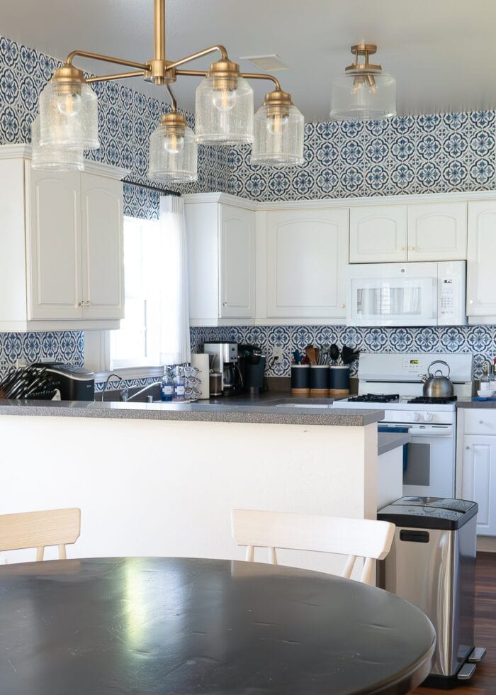 Small white kitchen with blue and white "tile" backsplash done with wallpaper