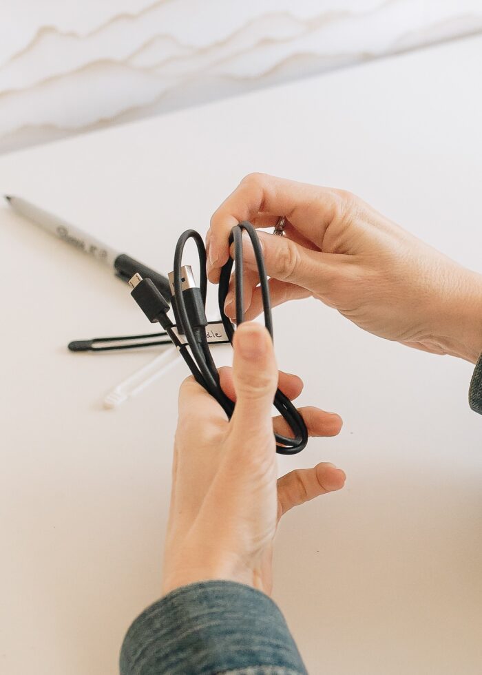 Megan wrapping a black cord into a tidy bundle