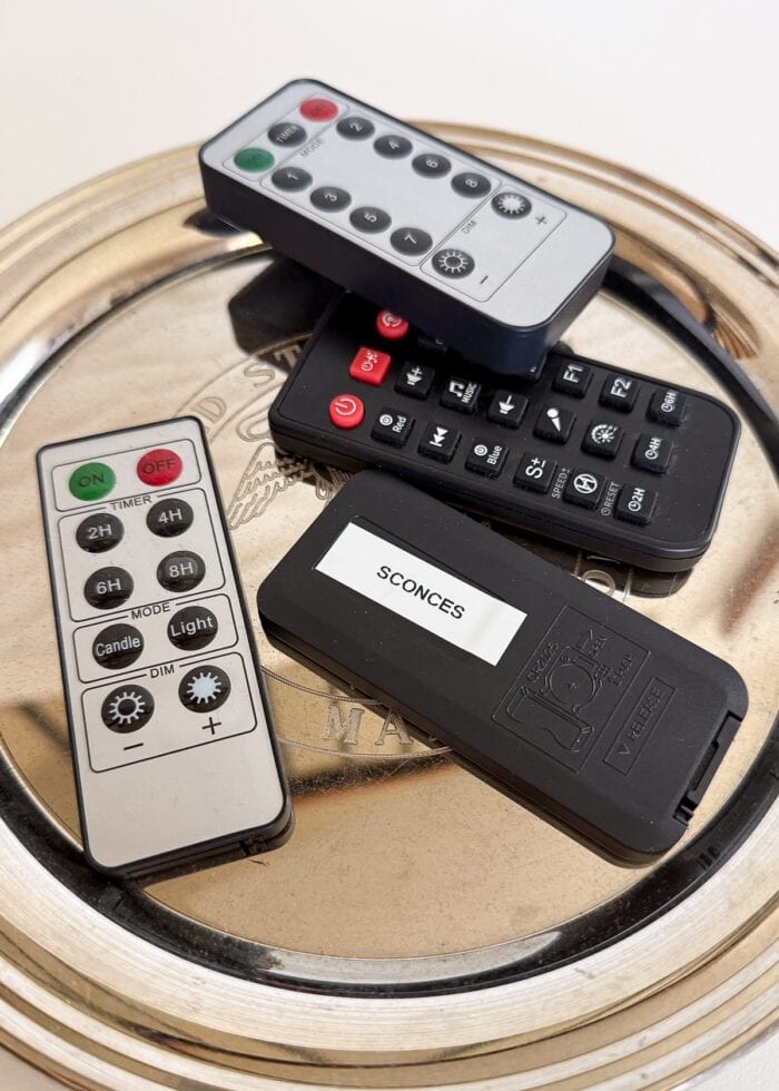 Mini remotes on a silver tray, one with a label on the back.