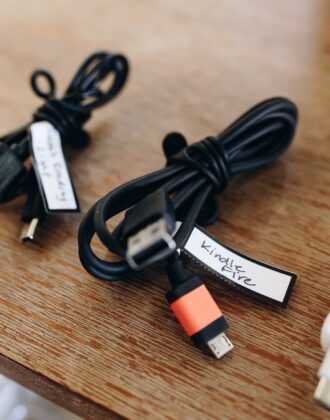 A black kindle cord with a hand-written label and secured with an elastic tie