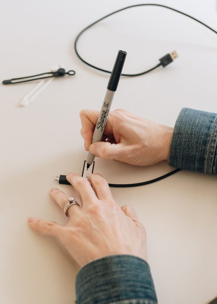 Megan writing onto a cord label with a Sharpie