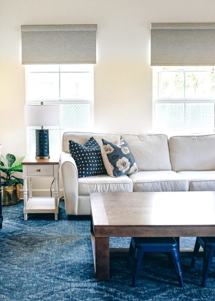 Blue and white family room with brown textured roller shades on the windows