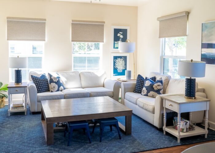 Blue and white family room with brown textured roller shades on the windows