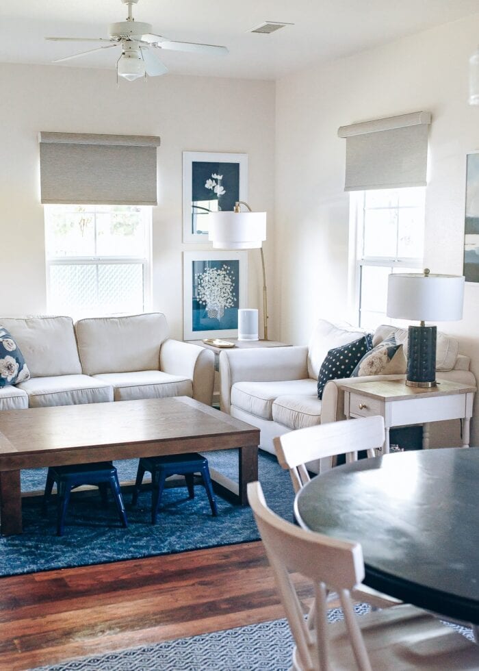Blue and white family room with brown textured roller shades on the windows