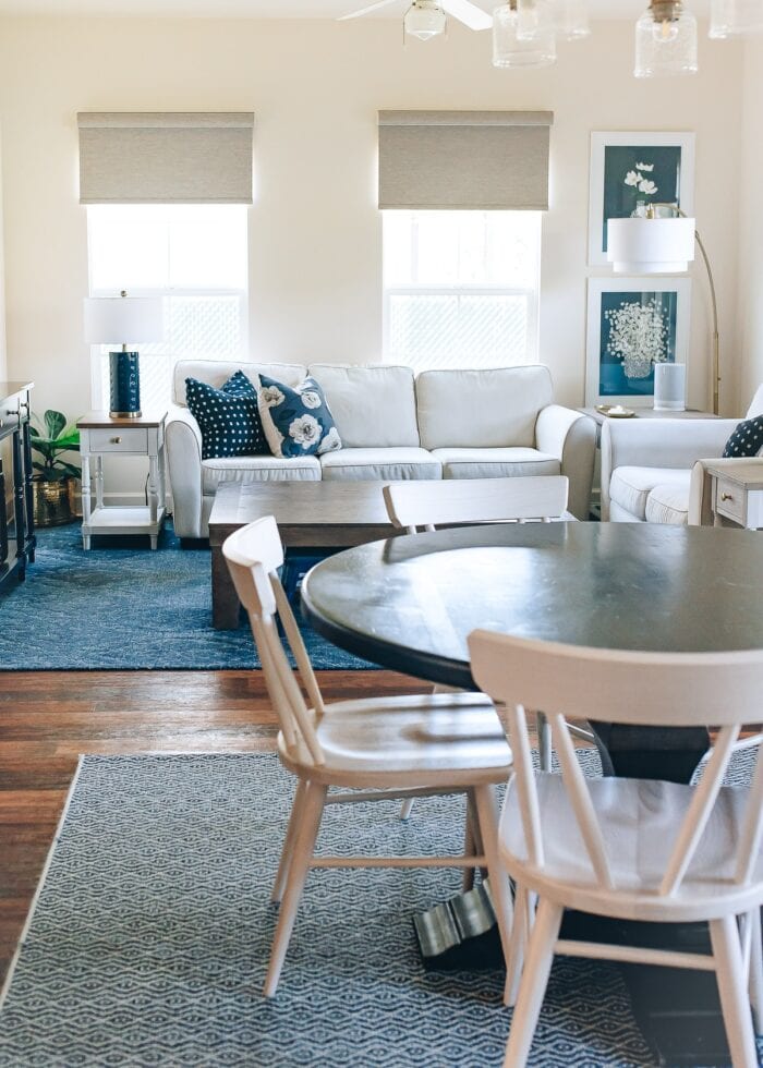 Blue and white family room with brown textured roller shades on the windows