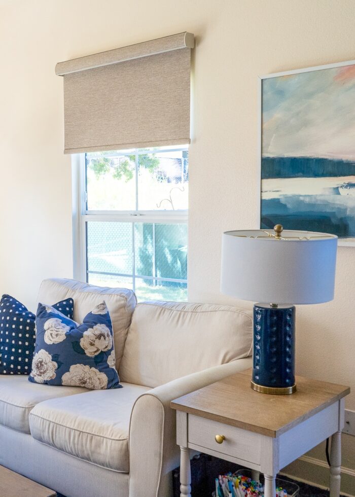 Brown blackout roller shade in a brown, white, and blue family room