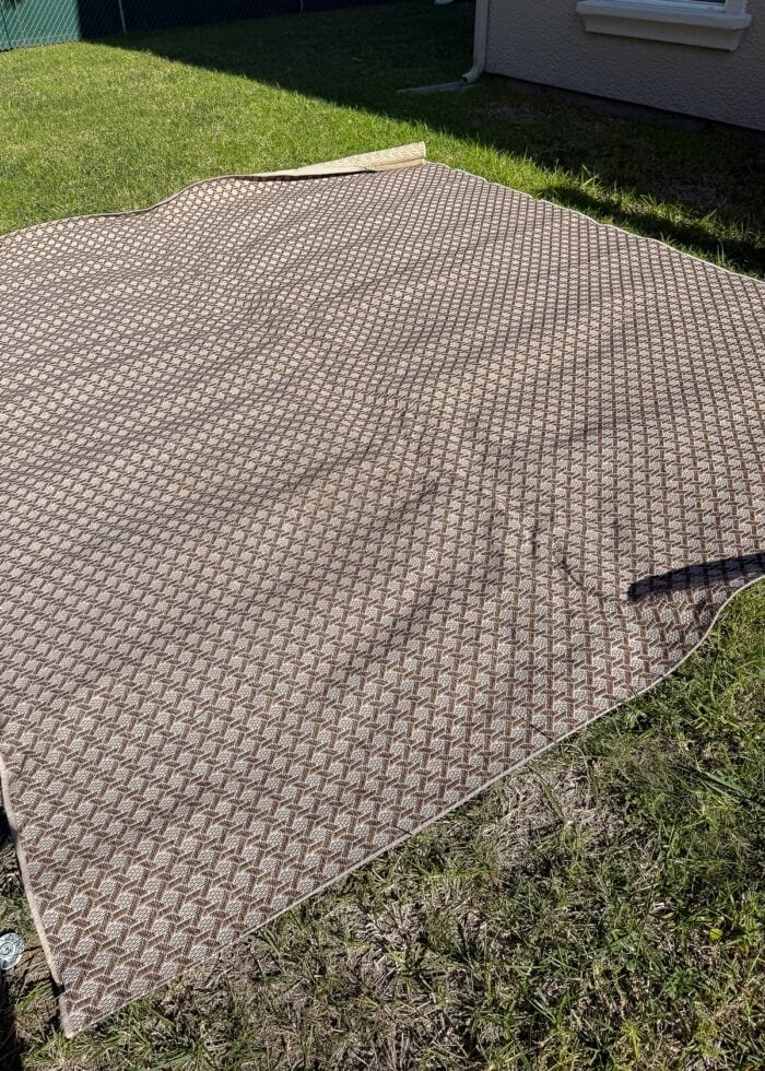 A wrinkled outdoor rug on a lawn