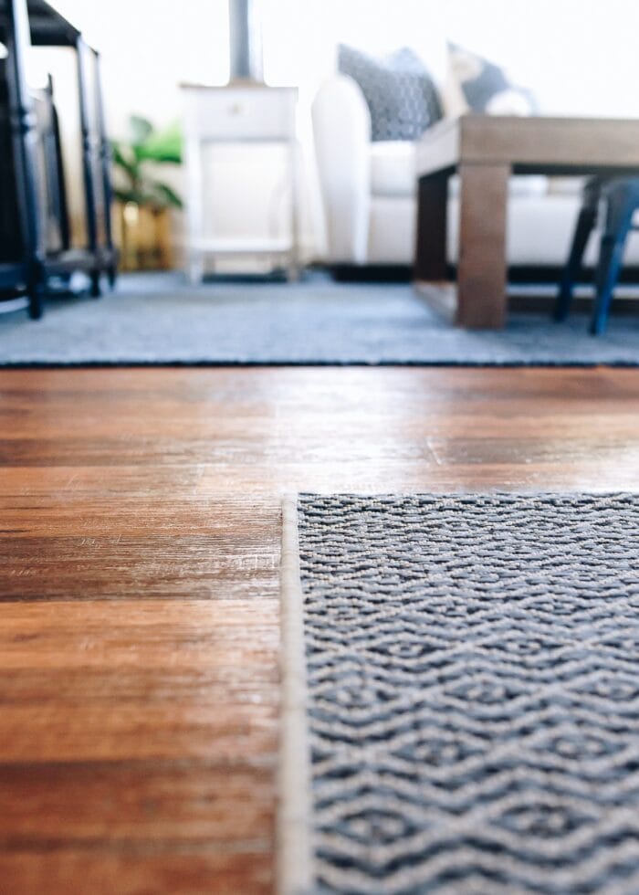 A close-up shot of two re-bound rugs on a wood floor