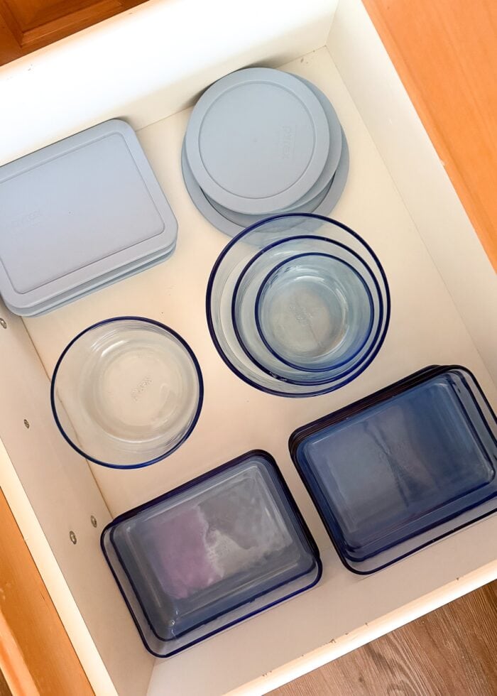 Blue food storage containers in a white drawer
