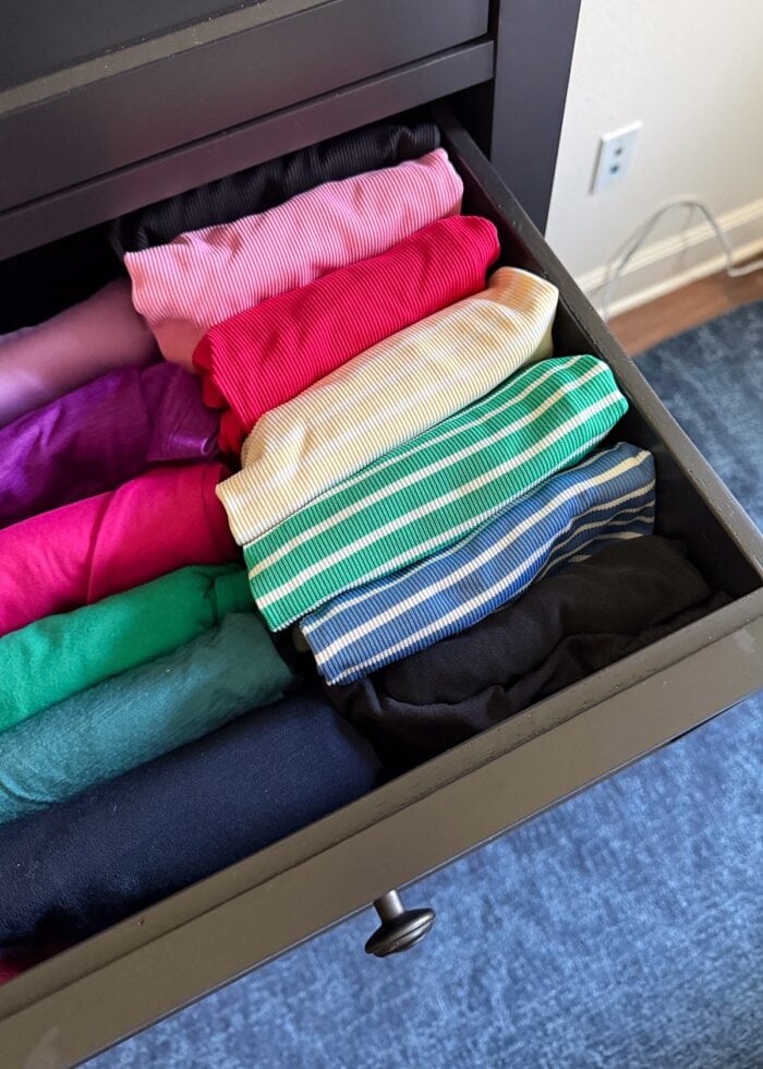 Shirts arranged by color in a drawer