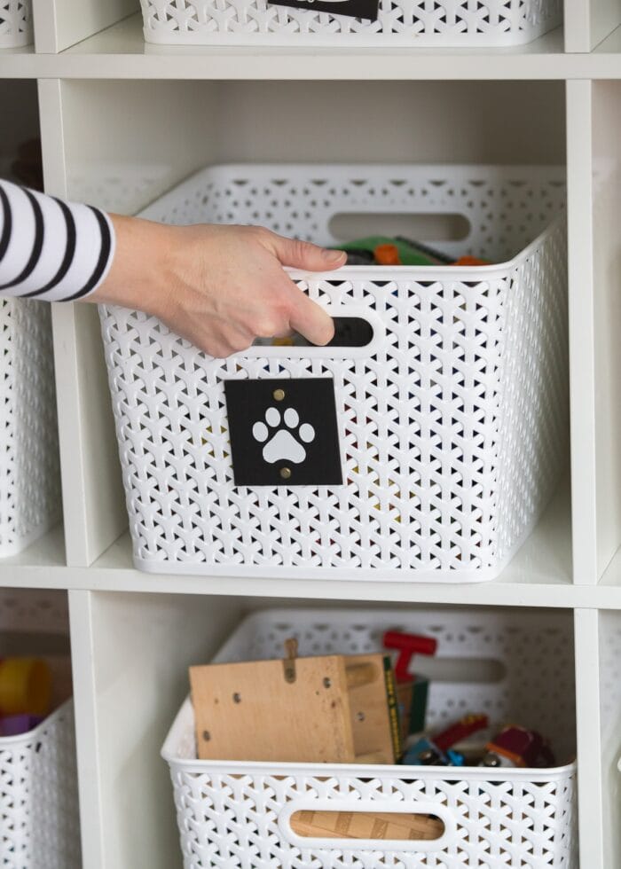 Hand pulling a white basket off a white shelf