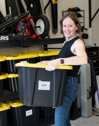 Megan carrying an HDX bin in a garage