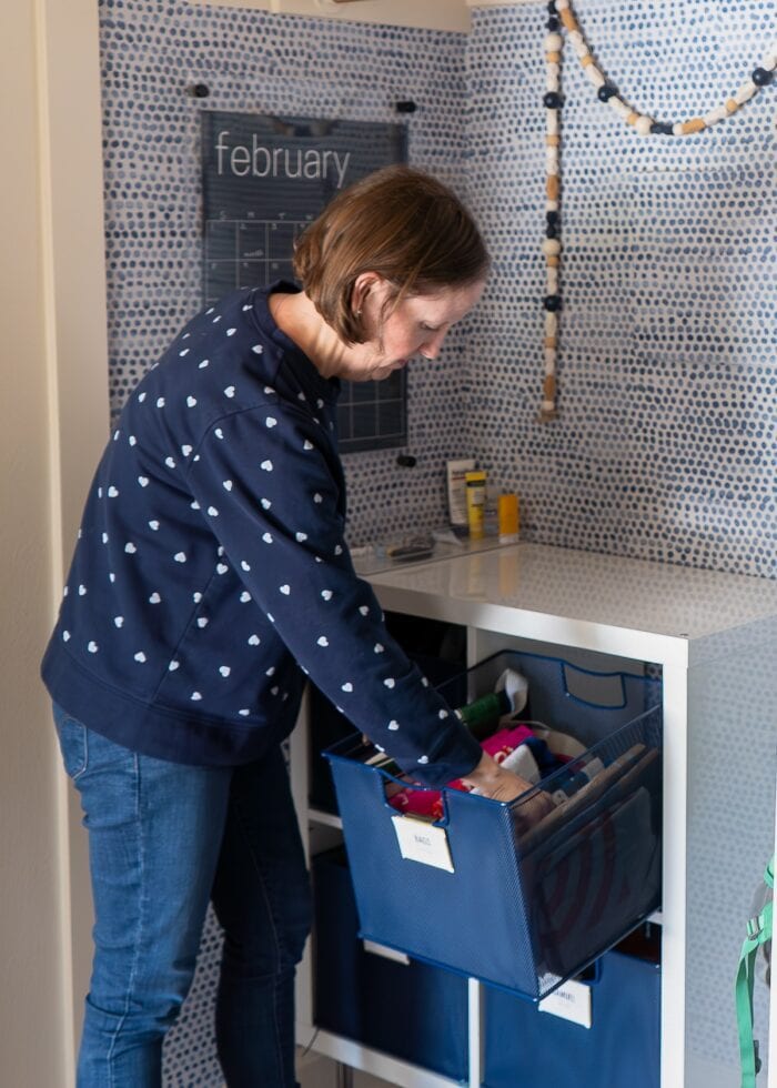 Megan from The Homes I Have Made going though a blue basket in a mudroom