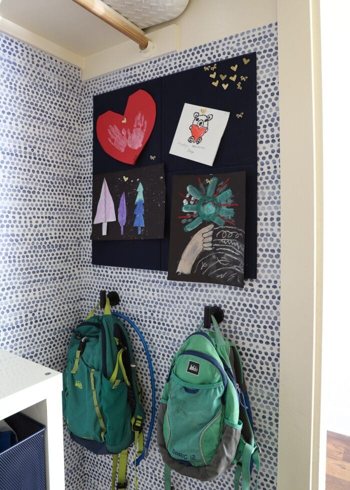 A blue felt bulletin board holding kids artwork