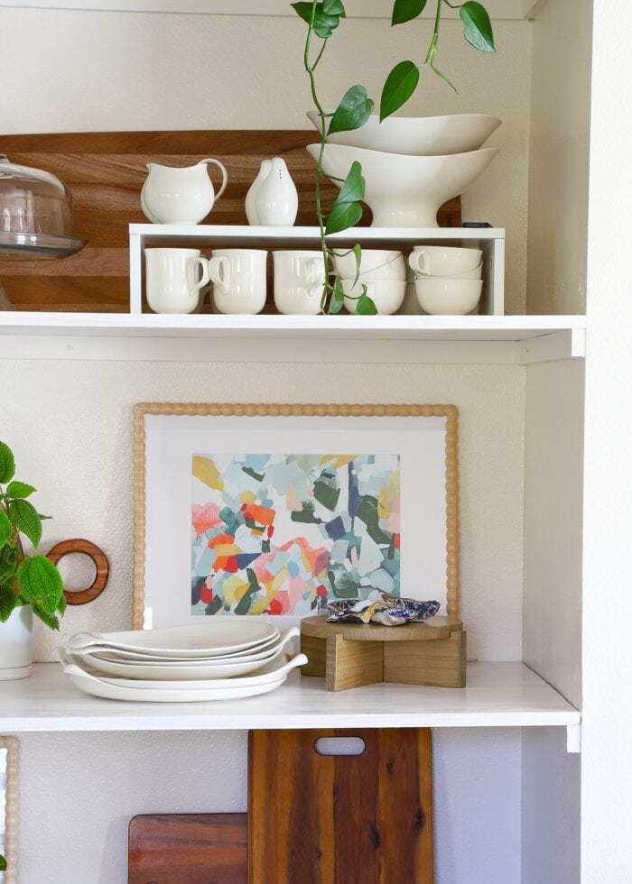 Basic floating shelves decorated with dishes, artwork, plants and decor accessories