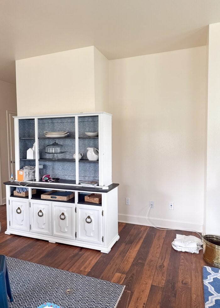 A large dining hutch sitting next to a large open nook on a wall.