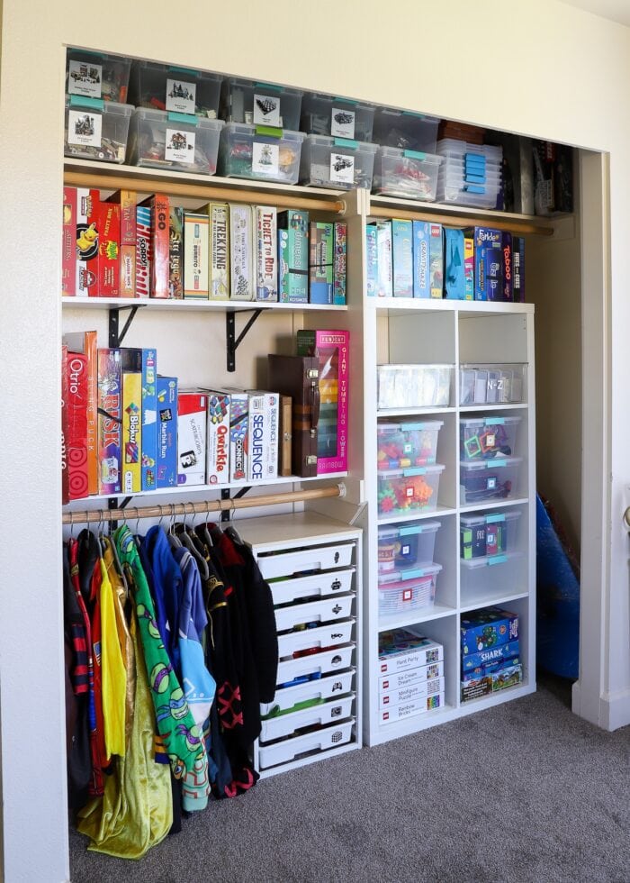An organized playroom closet filled with LEGO, games, toys, costumes and more.