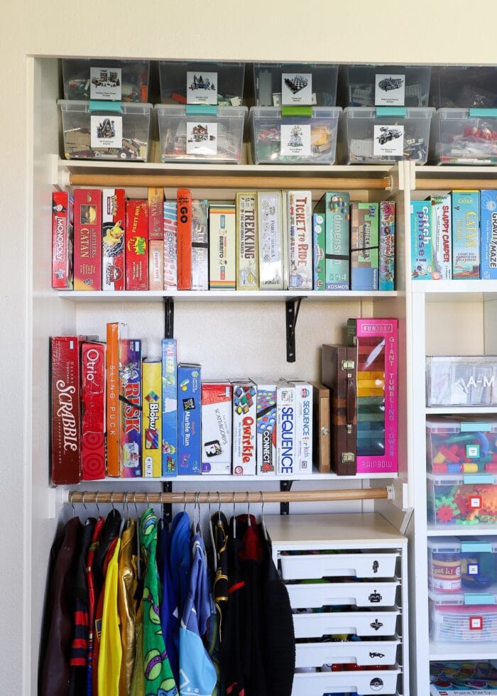 An organized playroom closet filled with LEGO, games, toys, costumes and more.