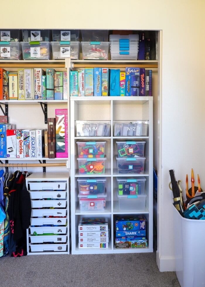 An organized playroom closet with games, toys, costumes and more.
