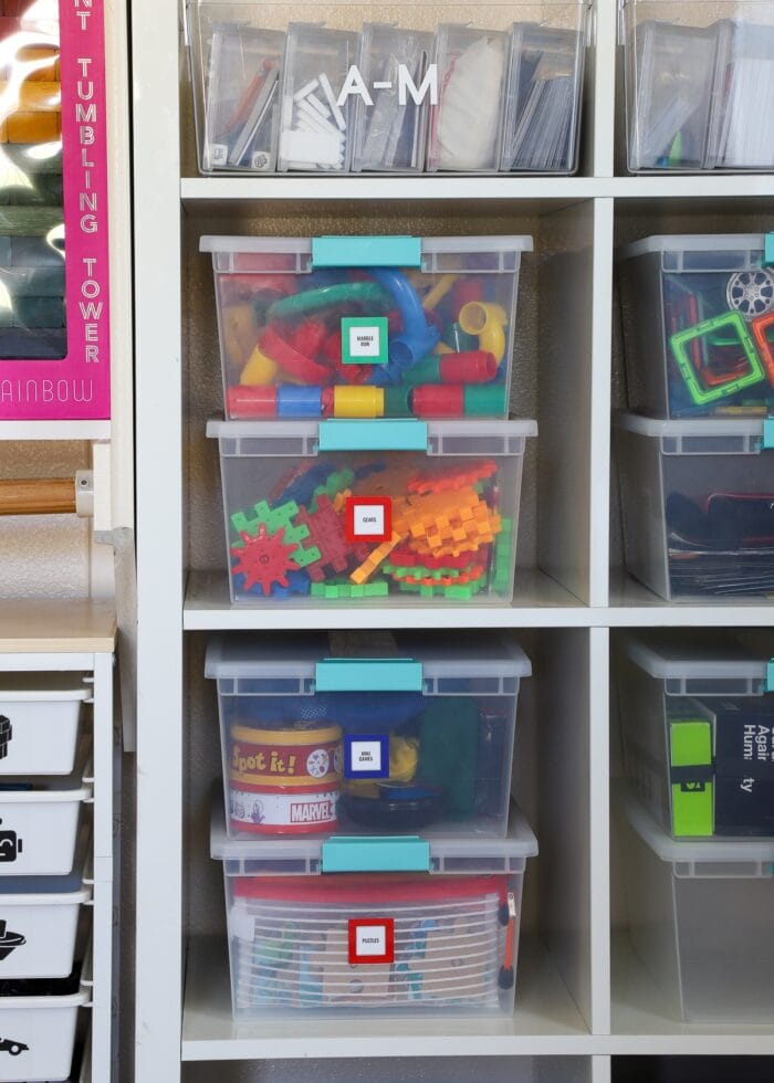 STEM games inside snap-lid boxes on a playroom closet shelf