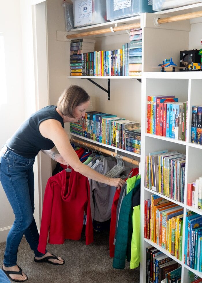Megan organizing jackets in an organized bedroom closet