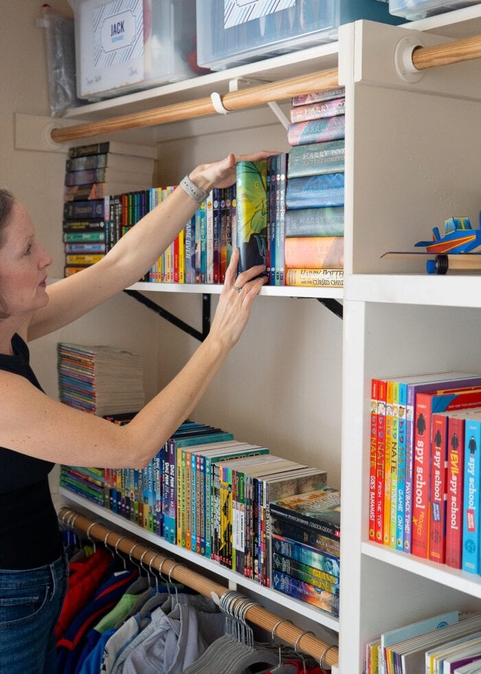 Megan organizing books on a closet shelf