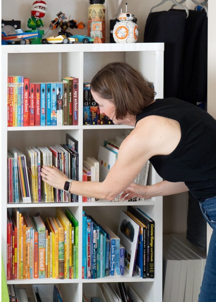 Megan organizing books on an IKEA Kallax shelf