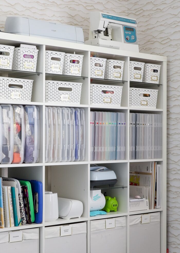 A 5x5 IKEA Kallax shelf filled with various bins, baskets, and cases holding a wide variety of craft supplies