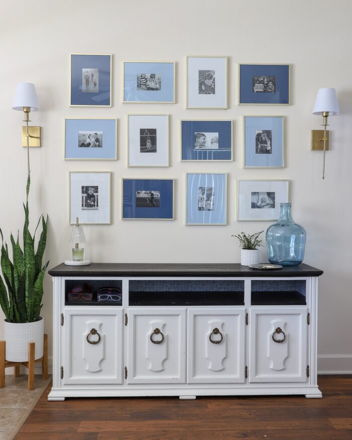 Foyer with a white console table and a collage of blue and white frames hung above