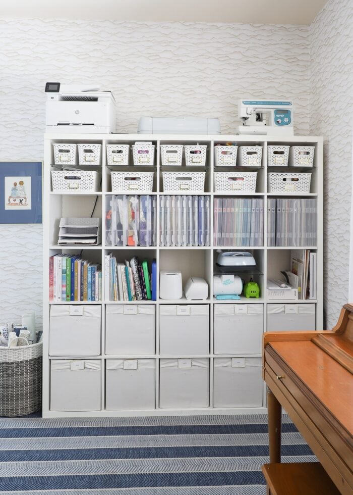 A 5x5 IKEA Kallax shelf filled with various bins, baskets, and cases holding a wide variety of craft supplies