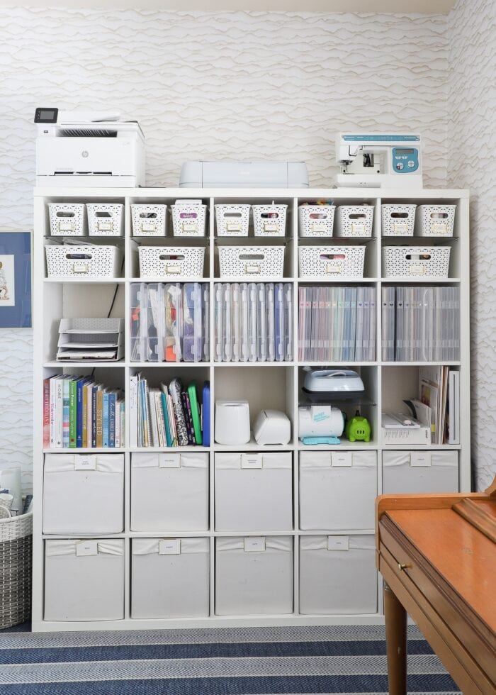 A 5x5 IKEA Kallax shelf filled with various bins, baskets, and cases holding a wide variety of craft supplies