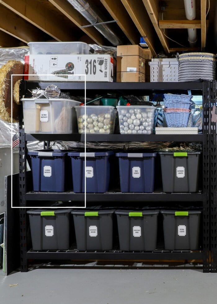 A basement storage shelf highlighting two large bins holding Nativity sets