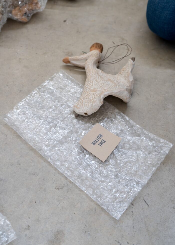 A Willow Tree angel shown alongside a bubble wrap pouch