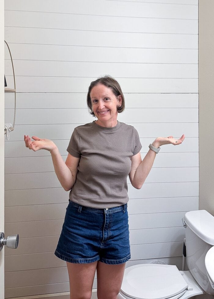 Megan in front of a white shiplap bathroom wall